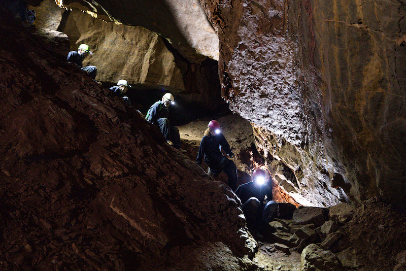 People crawling in a cave.