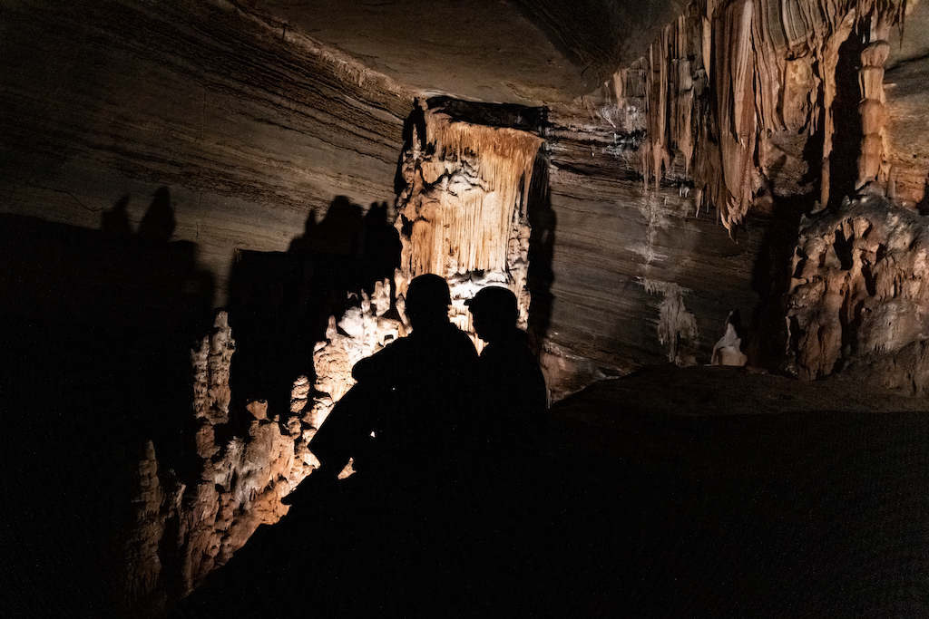 People exploring a cave with lights.